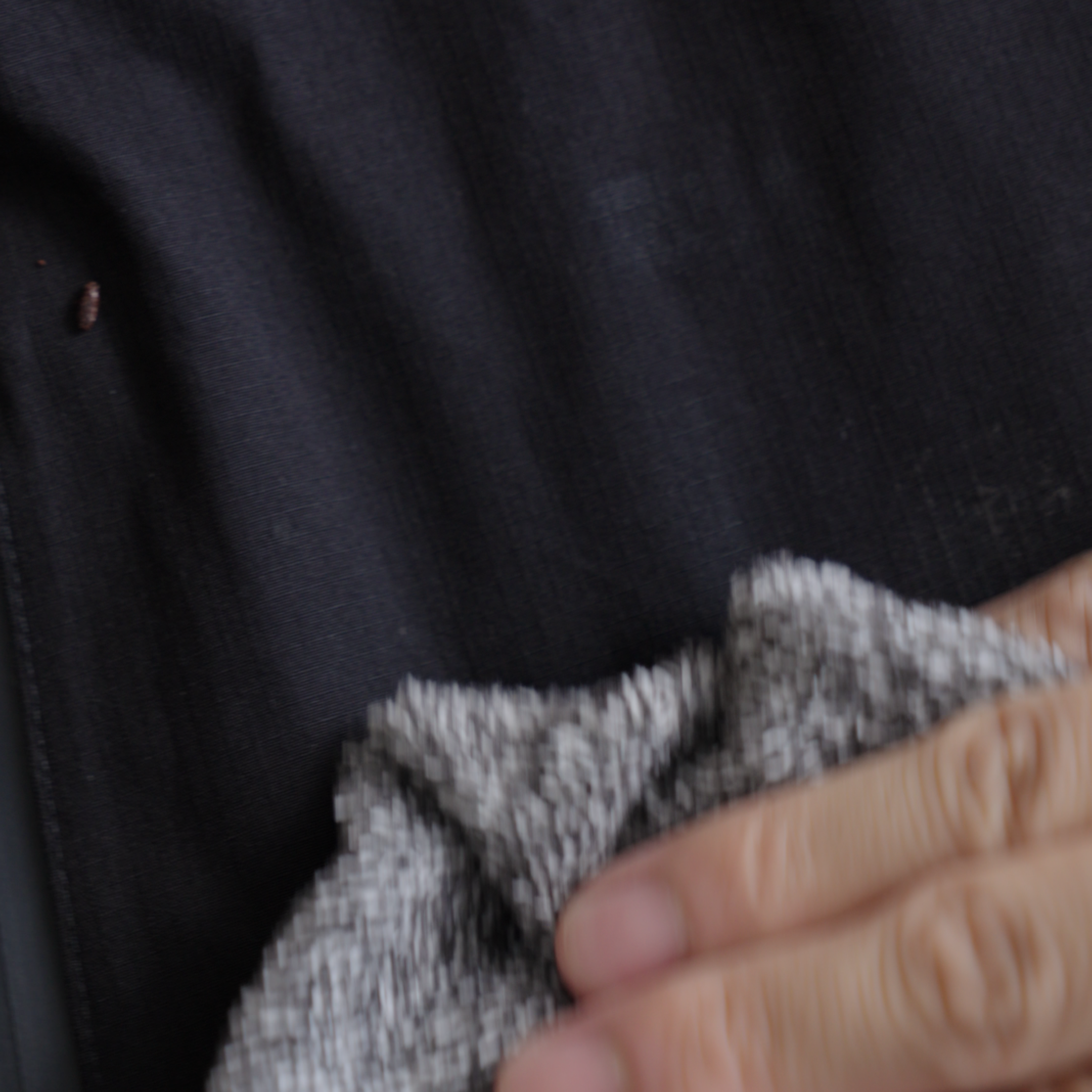 Hand cleaning a waterproof shell surface with a gray cloth